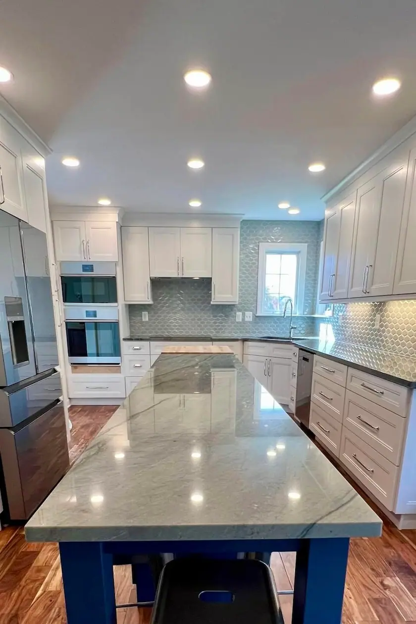 Bright white kitchen with a large island and gray stone countertop