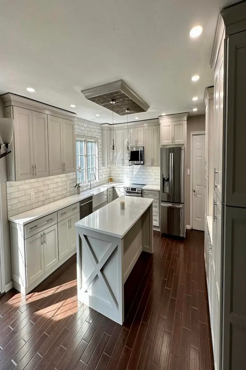 White kitchen with an X-brace island and stainless steel appliances
