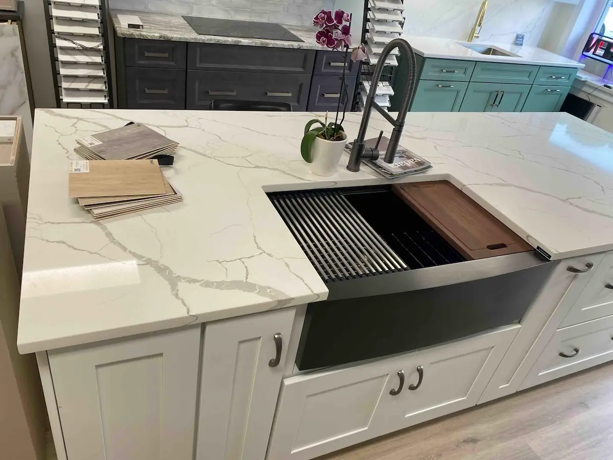 Kissel Hill Cabinets showroom display with white cabinets and a quartz countertop with a workstation sink